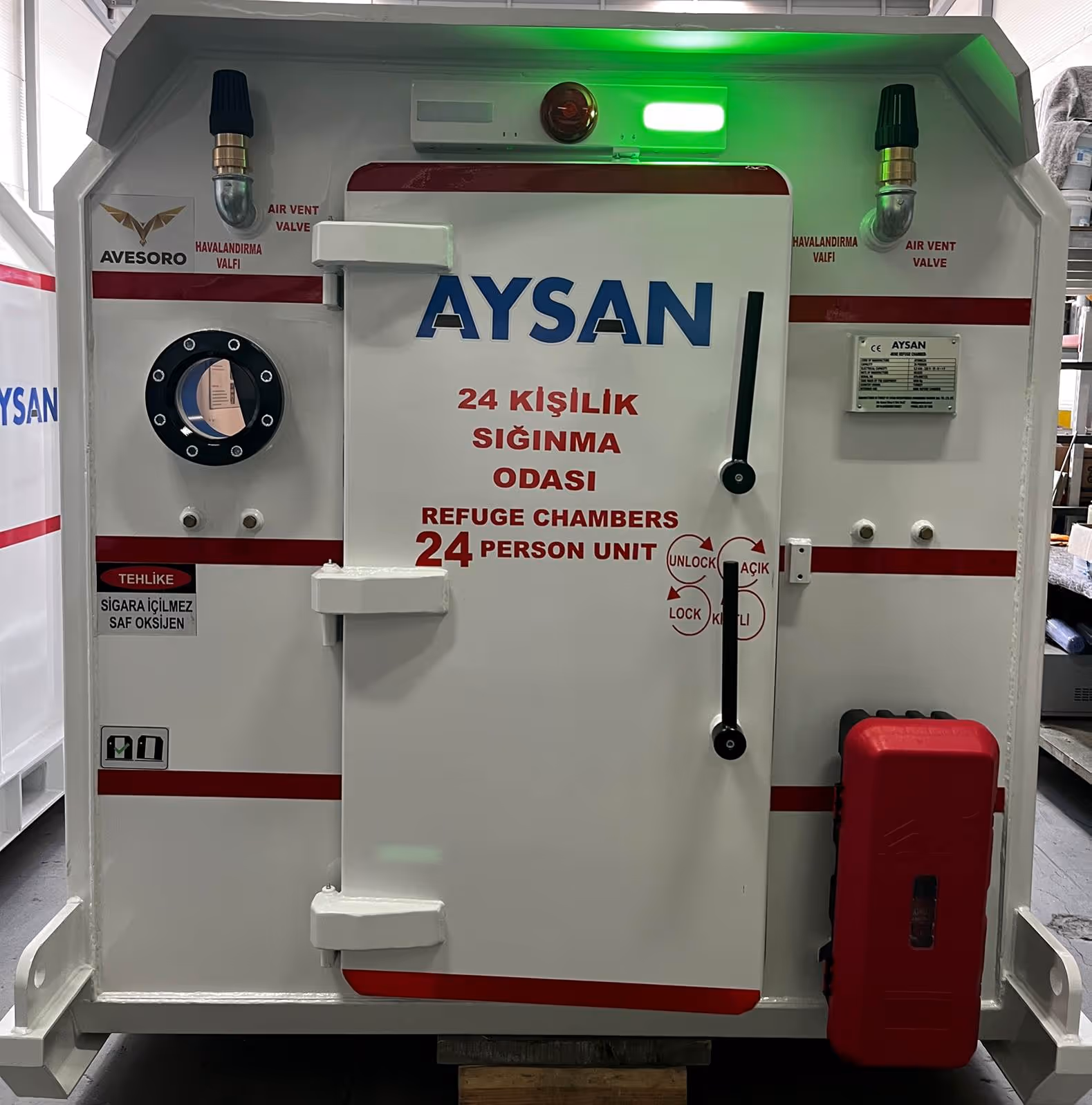 Cámara de refugio Aysan diseñada para 24 personas con puerta cerrada, ventilaciones y señales de seguridad.