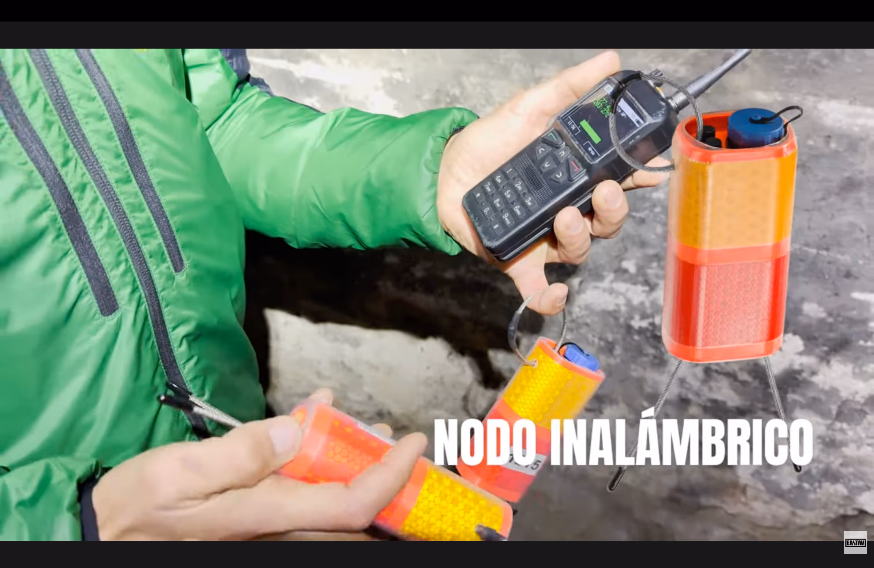 Persona en chaqueta verde sosteniendo radio transmisor inalámbrico de emergencia