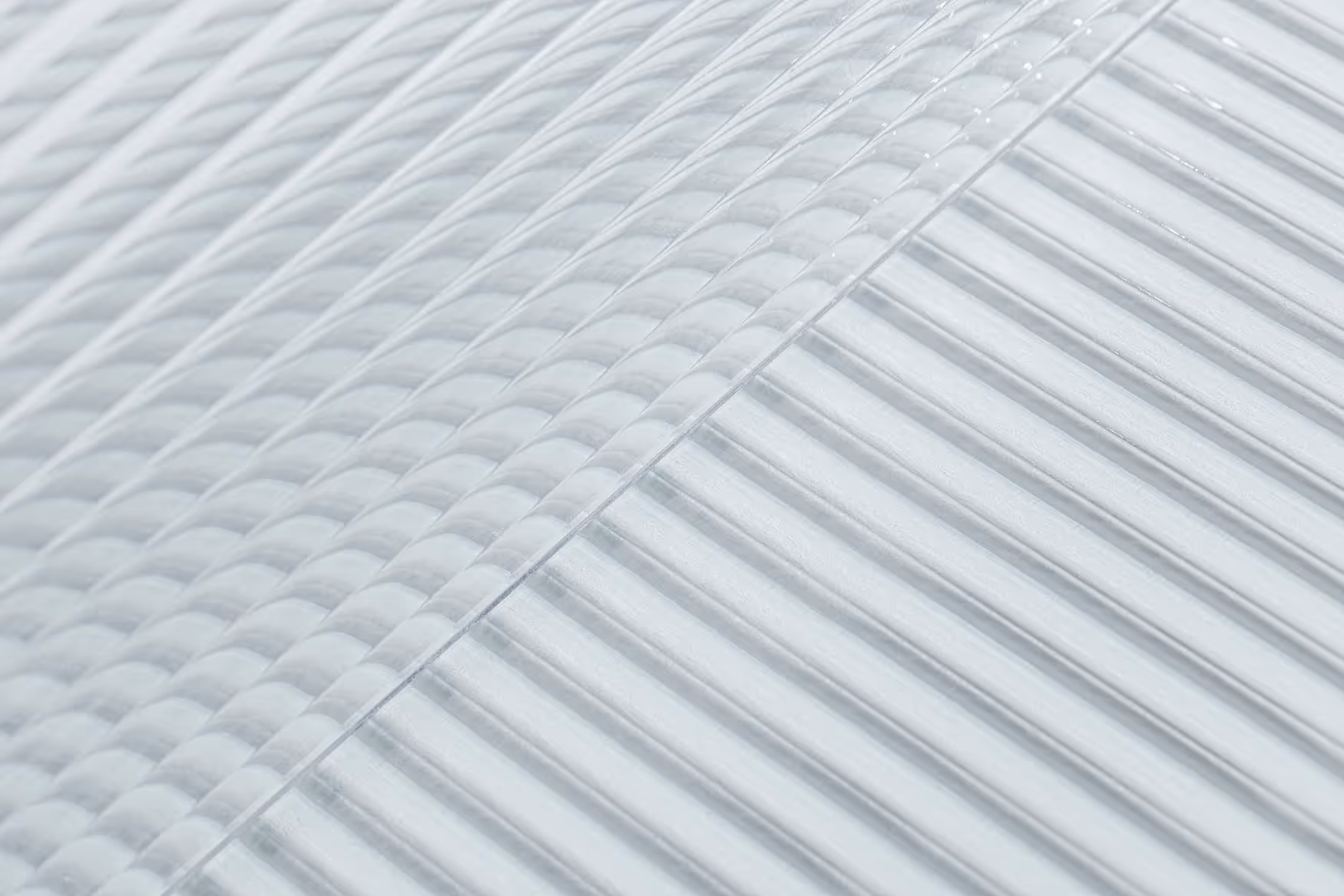 Superficie transparente con un patrón de textura de vidrio compuesto por líneas y formas geométricas.