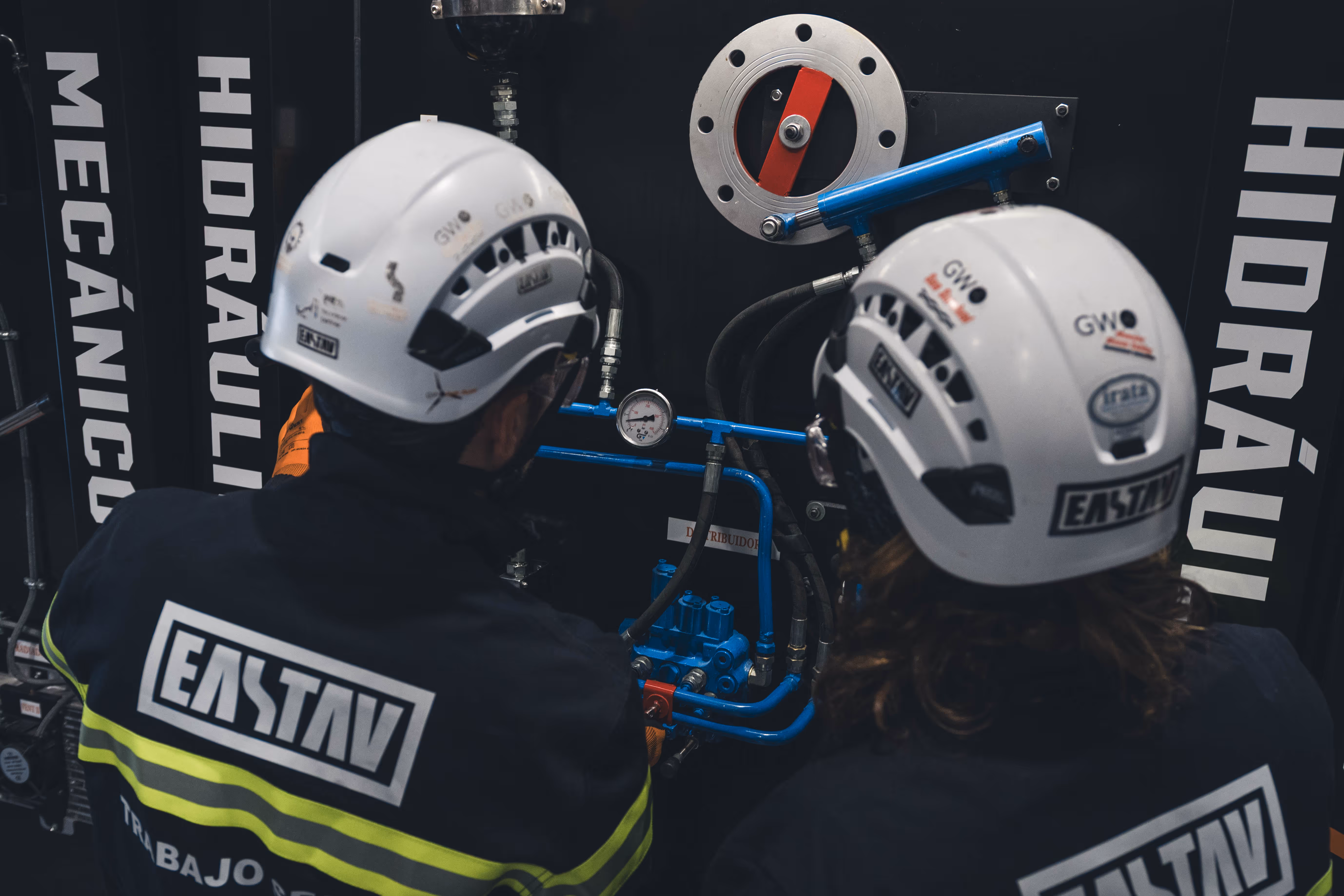 Formación GWO con cascos de seguridad blanco y equipos de altura industrial.