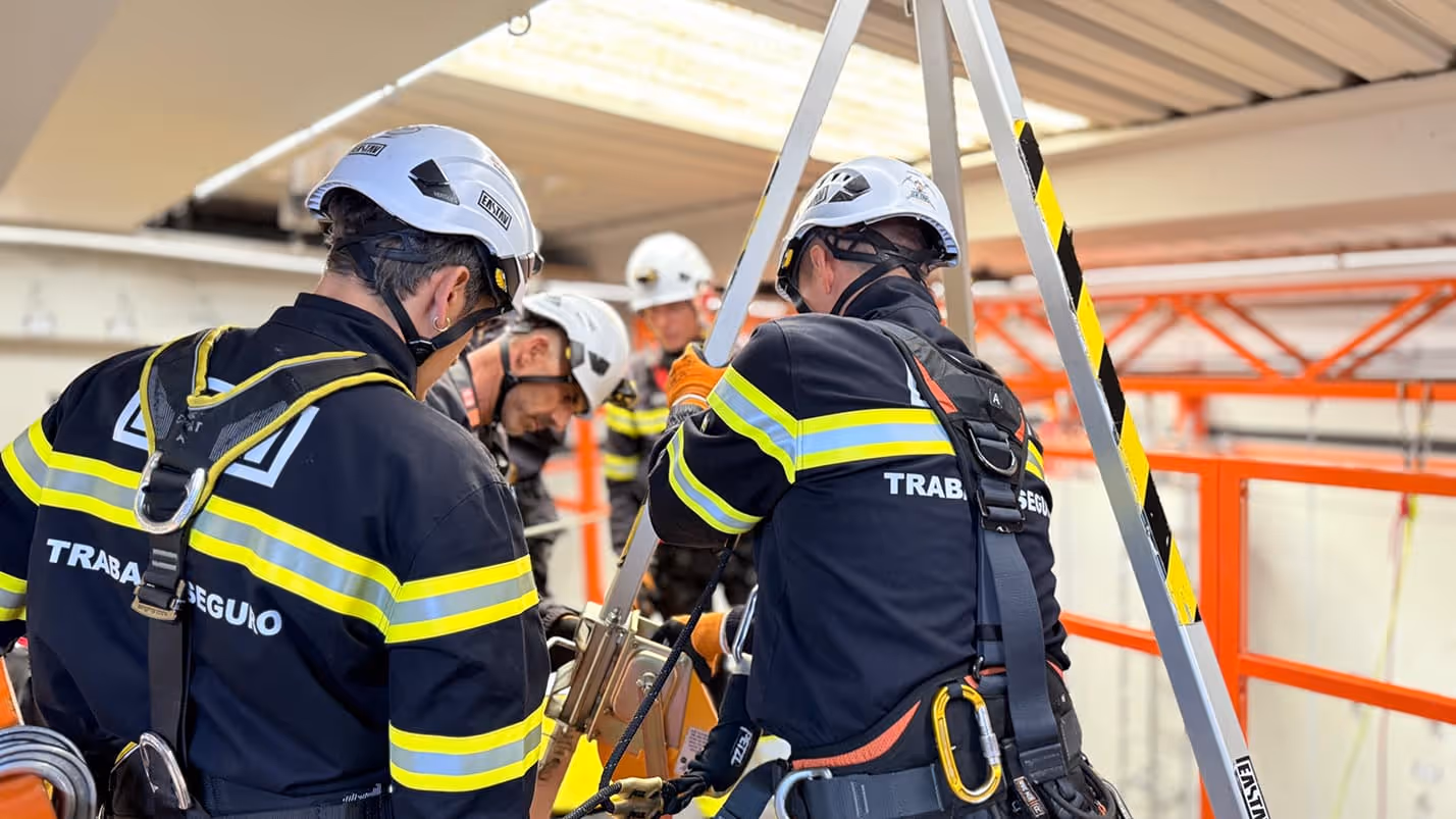 Trabajadores de altura en equipo de seguridad dentro de una obra en construcción.