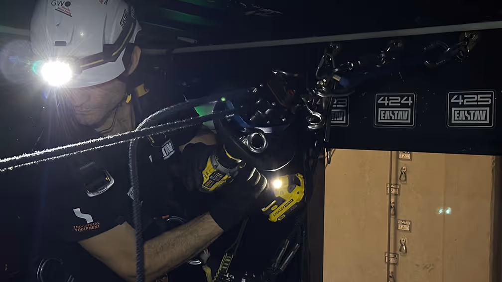 Buzo explorando el interior oscuro de un barco hundido con equipo de buceo profesional.