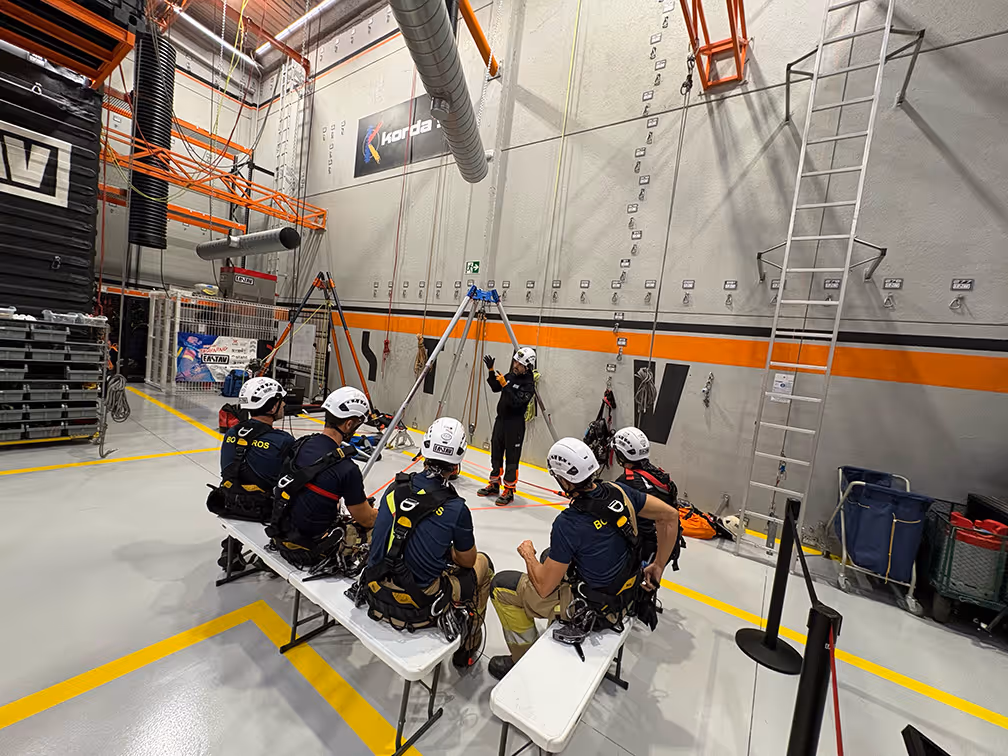 Equipo de rescate con cuerdas en hangar de entrenamiento industrial