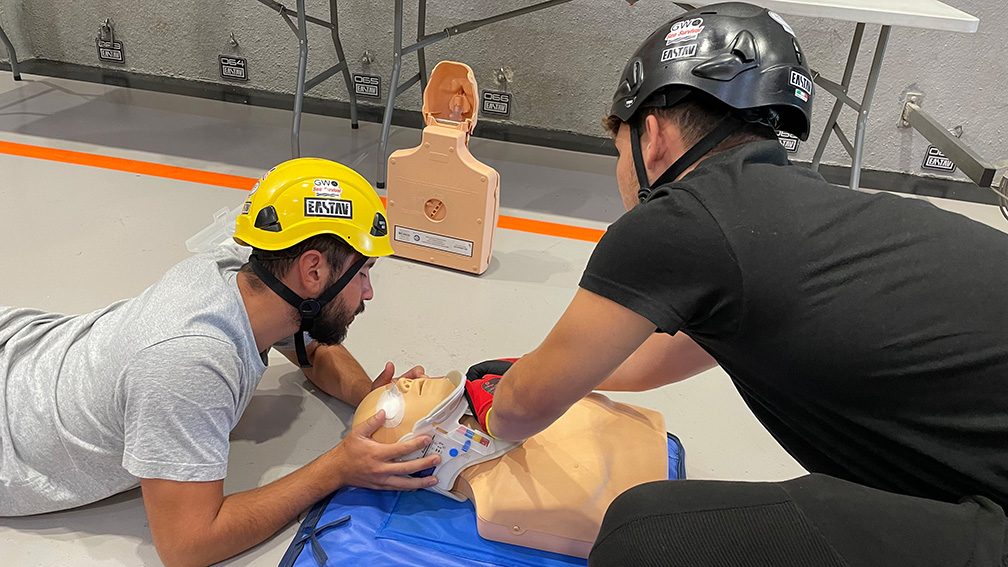 Dos instructores practicando técnicas de primeros auxilios y reanimación cardiopulmonar en maniquí.