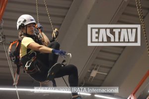 Trabajador con casco amarillo realiza trabajo en altura con equipos de seguridad.