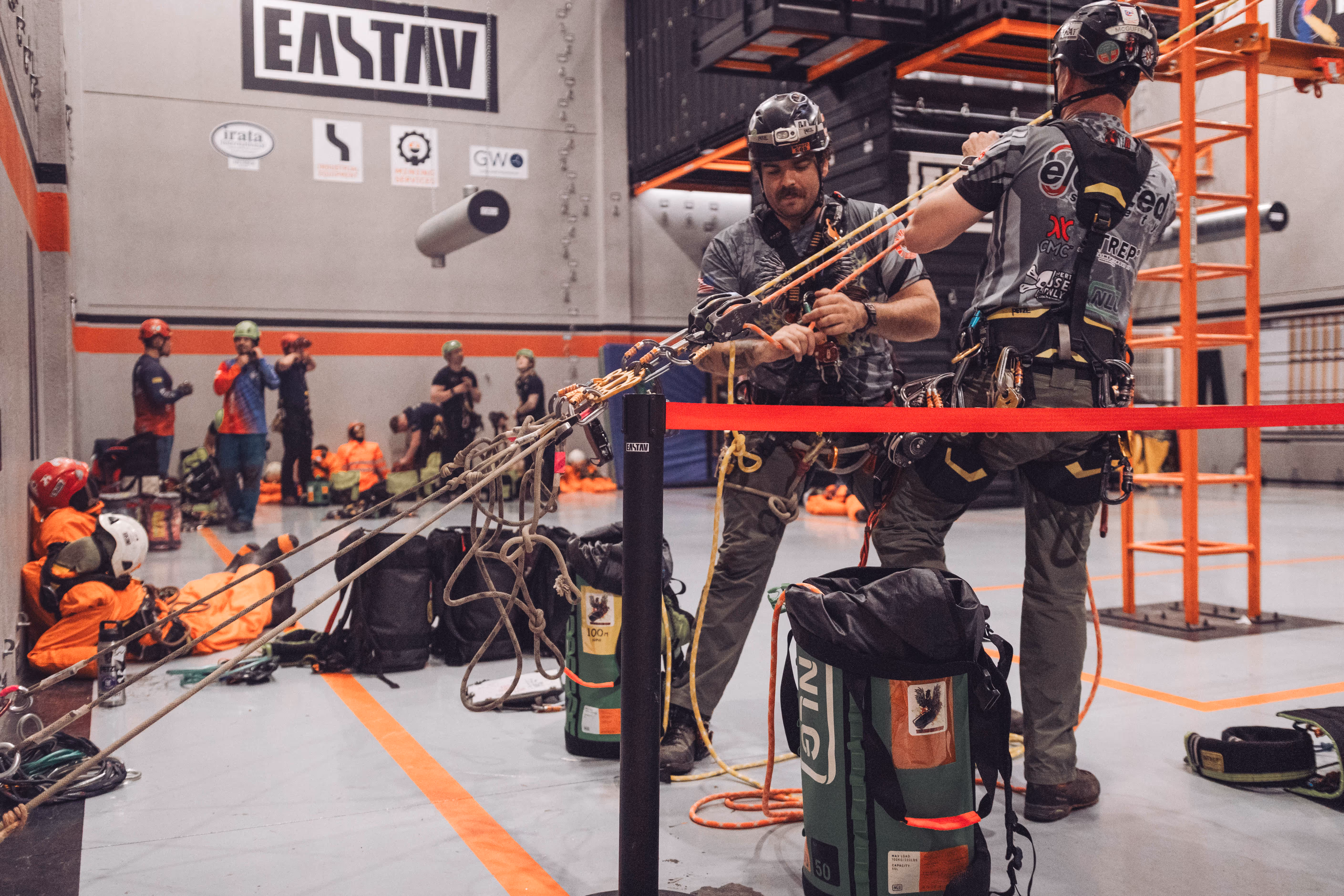 Instructores de rescate en altura demostrando técnicas de rapel con equipo de seguridad profesional.