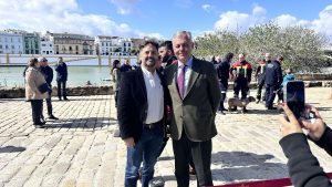 Grupo de personas en traje junto al agua durante un evento formal