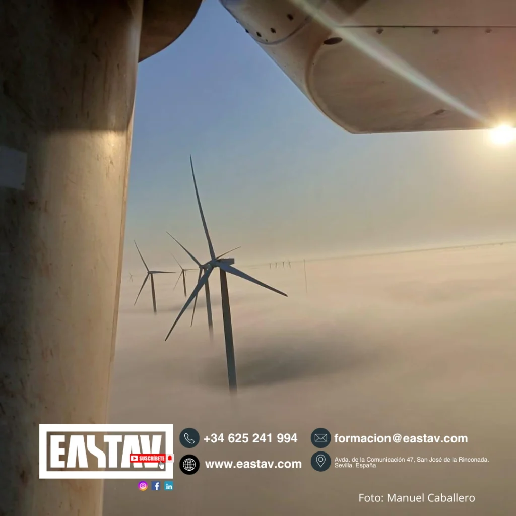 Wind turbines partially shrouded in fog viewed from aircraft window during daytime