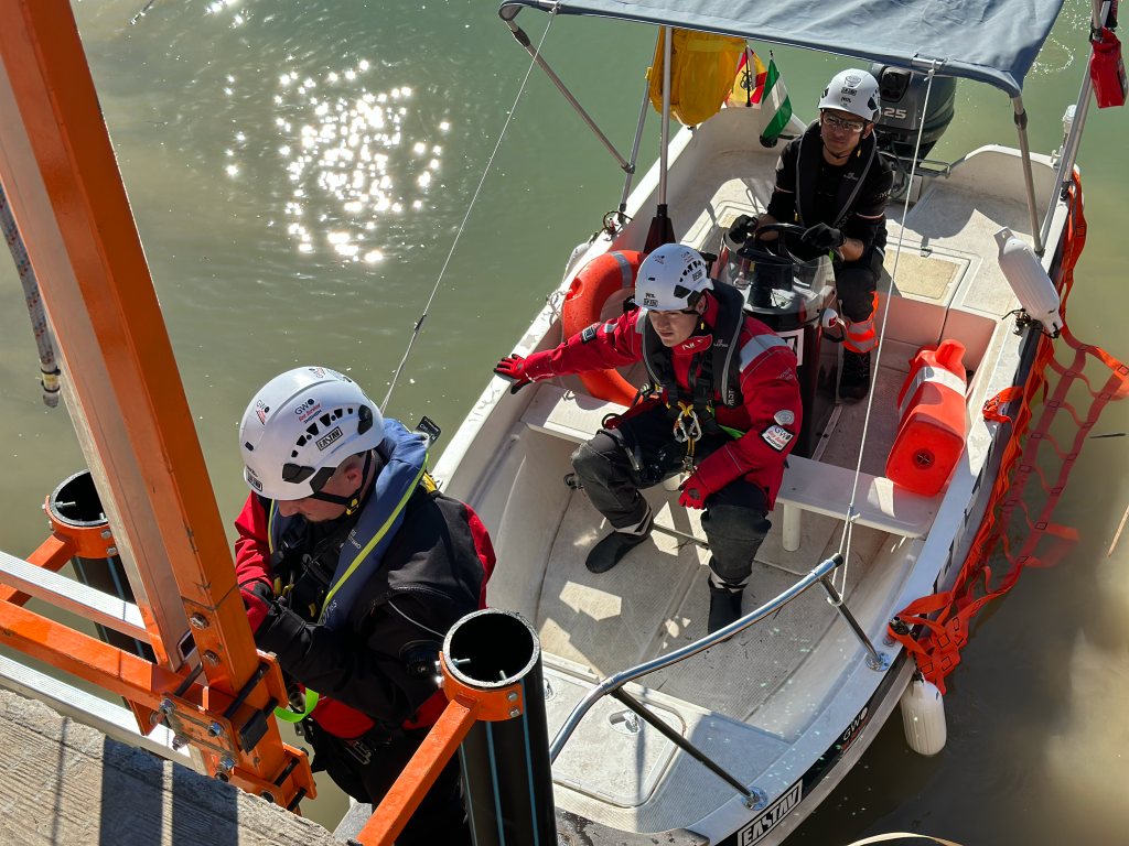 Water rescue team training in inflatable boat with safety equipment and helmets