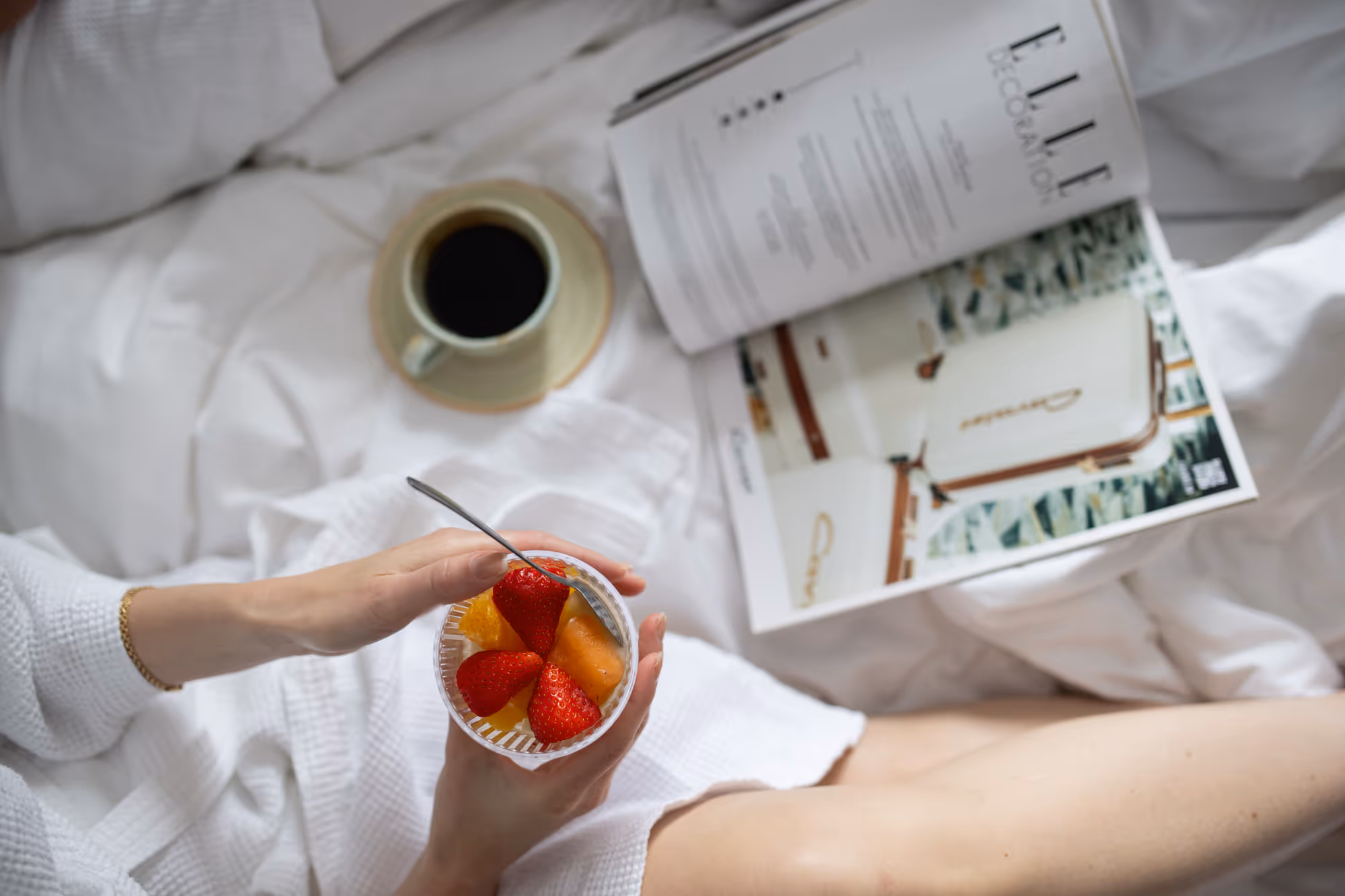 Frukost på sängen med kaffe, frukt och tidning.