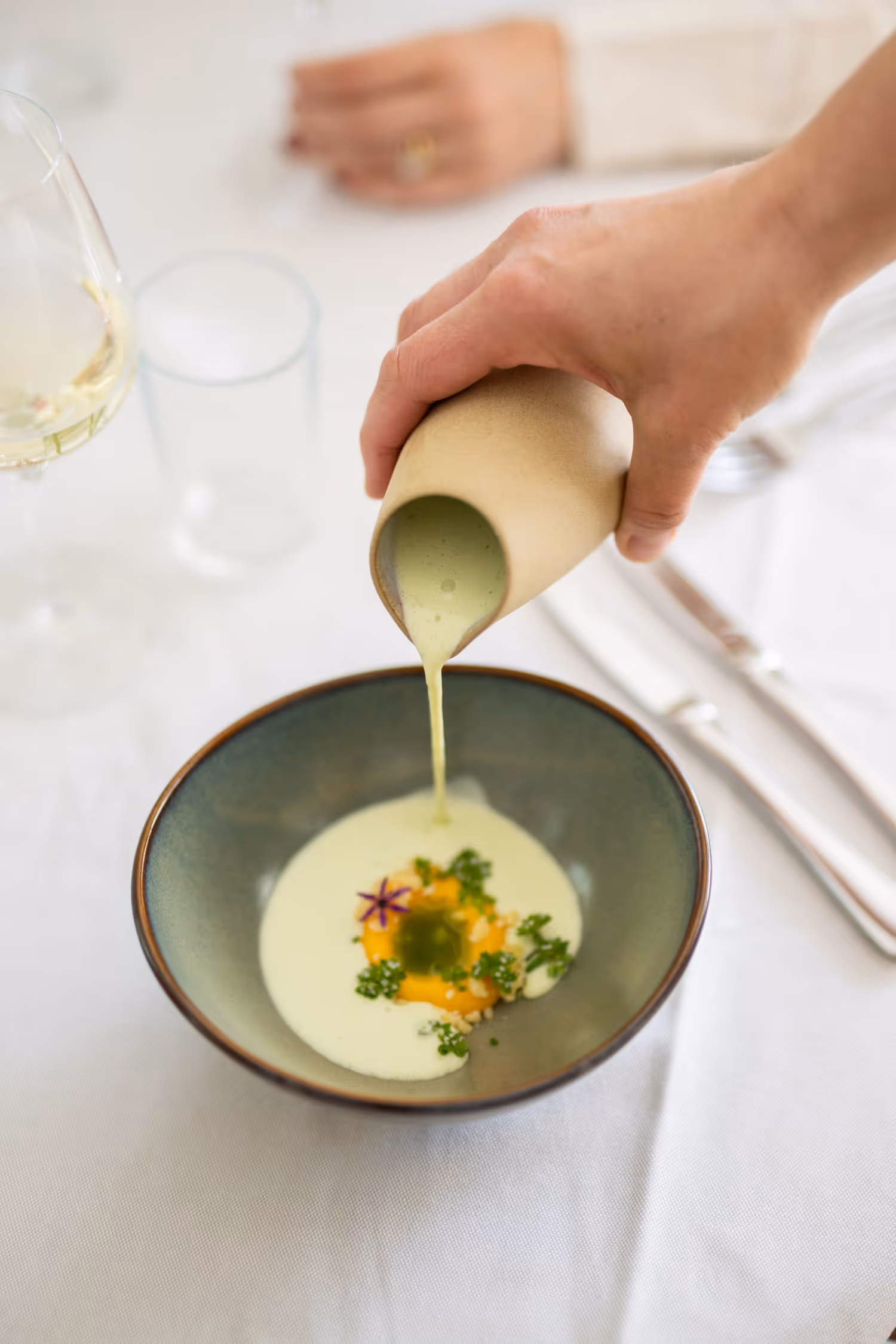 Gourmet soppa med örter, serverad i keramikskål.
