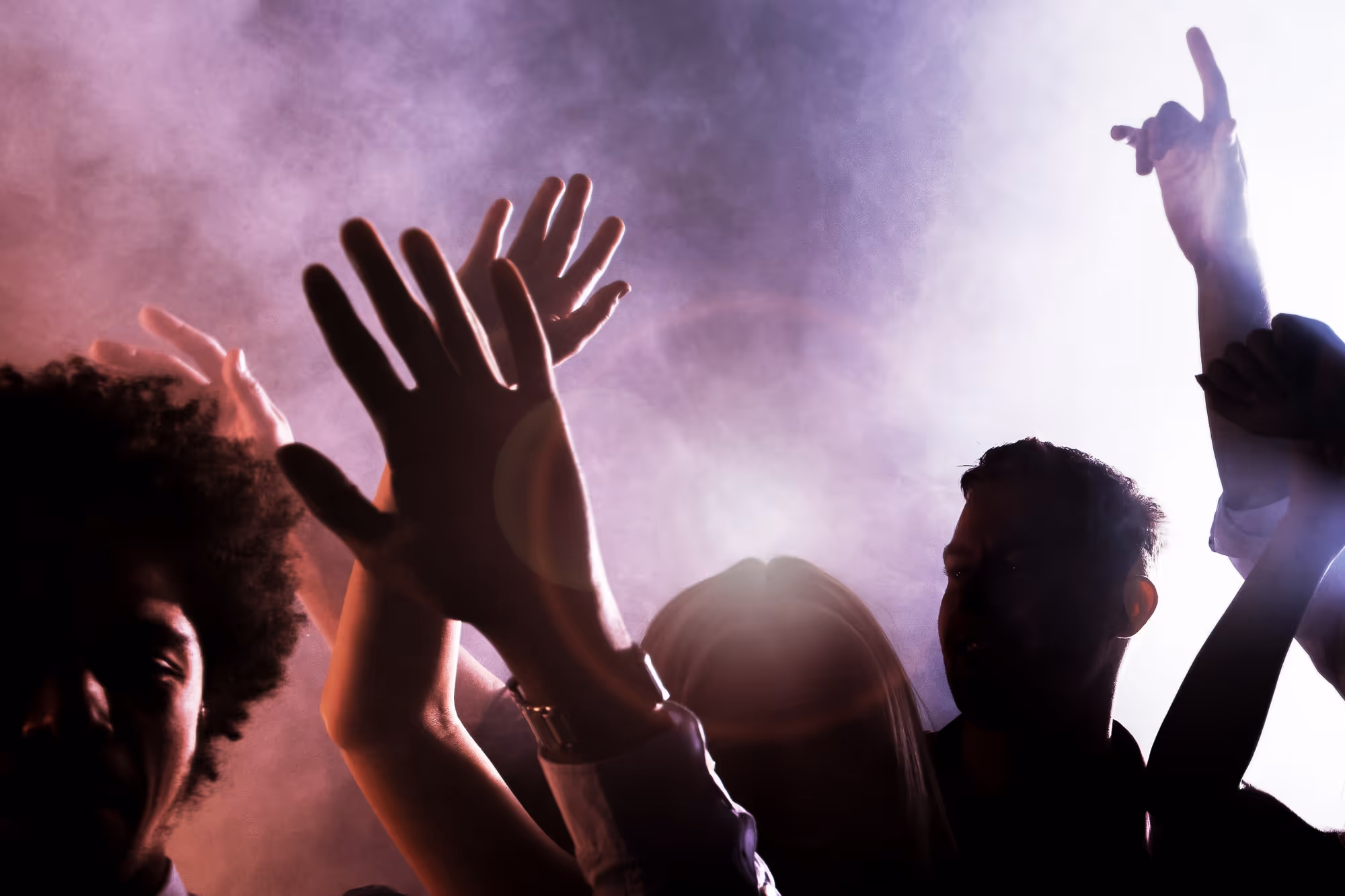 Folk som dansar med händerna i luften