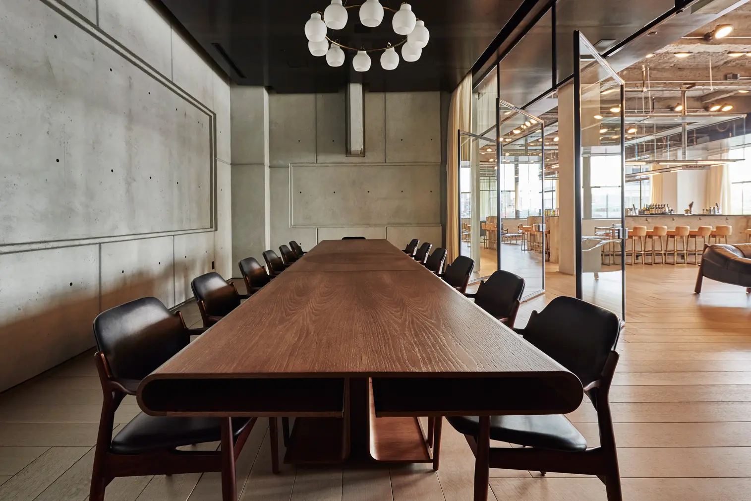 Modern conference room at Spring Place with wooden table and adjoining lounge area