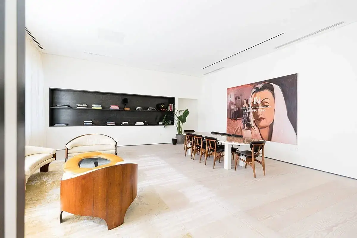 Modern room at Spring Place with large painting, long table, chairs, and corner plant