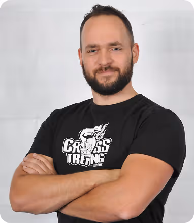 Trener Janusz prowadzący trening cross‑training ze sztangą