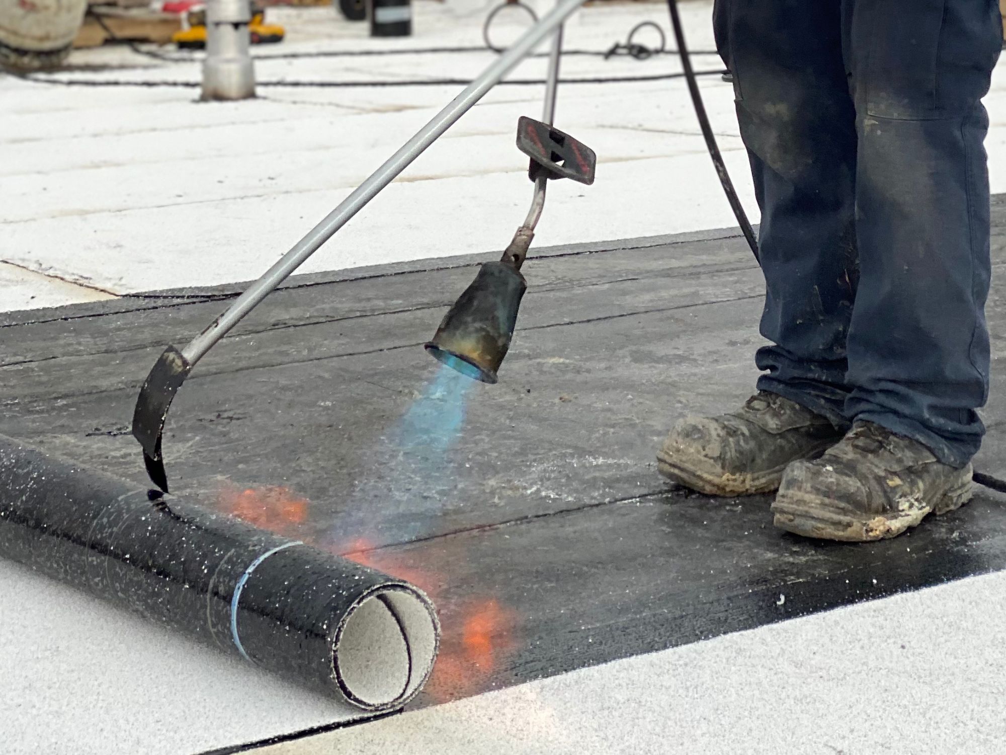Chalumeau et soudure de membrane élastomère sur un toit