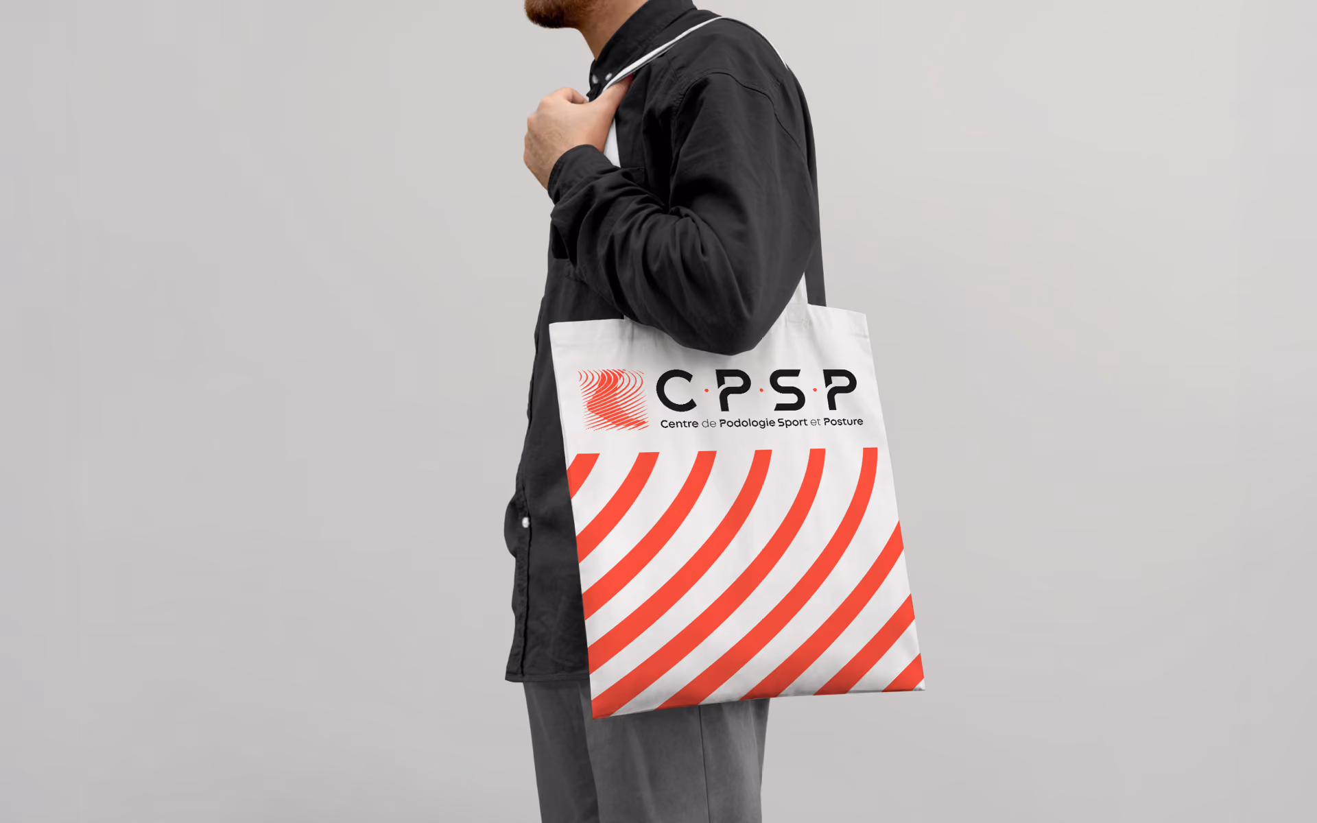 Homme portant un tote bag du Centre de Podologie du Sport et Posture