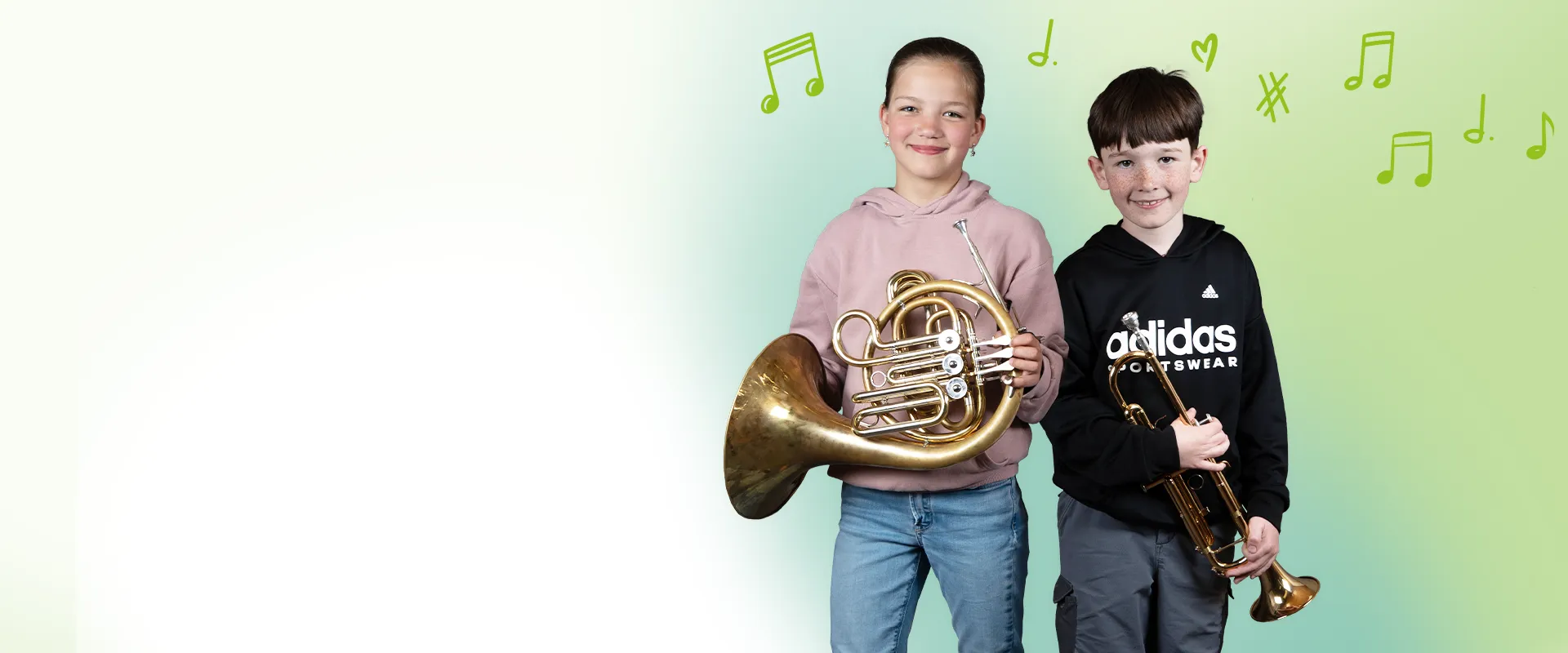 Bild von der Jugendmusikkapelle Kiefersfelden:
Zwei Kinder vor grün-blauem Verlauf mit Notensymbolen. Sie halten ein Waldhorn und eine Trompete und lächeln in die Kamera.