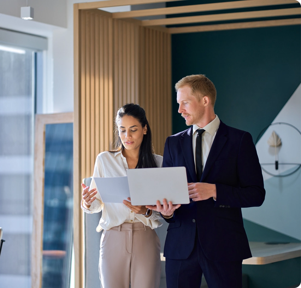 Two business professionals reviewing documents in office