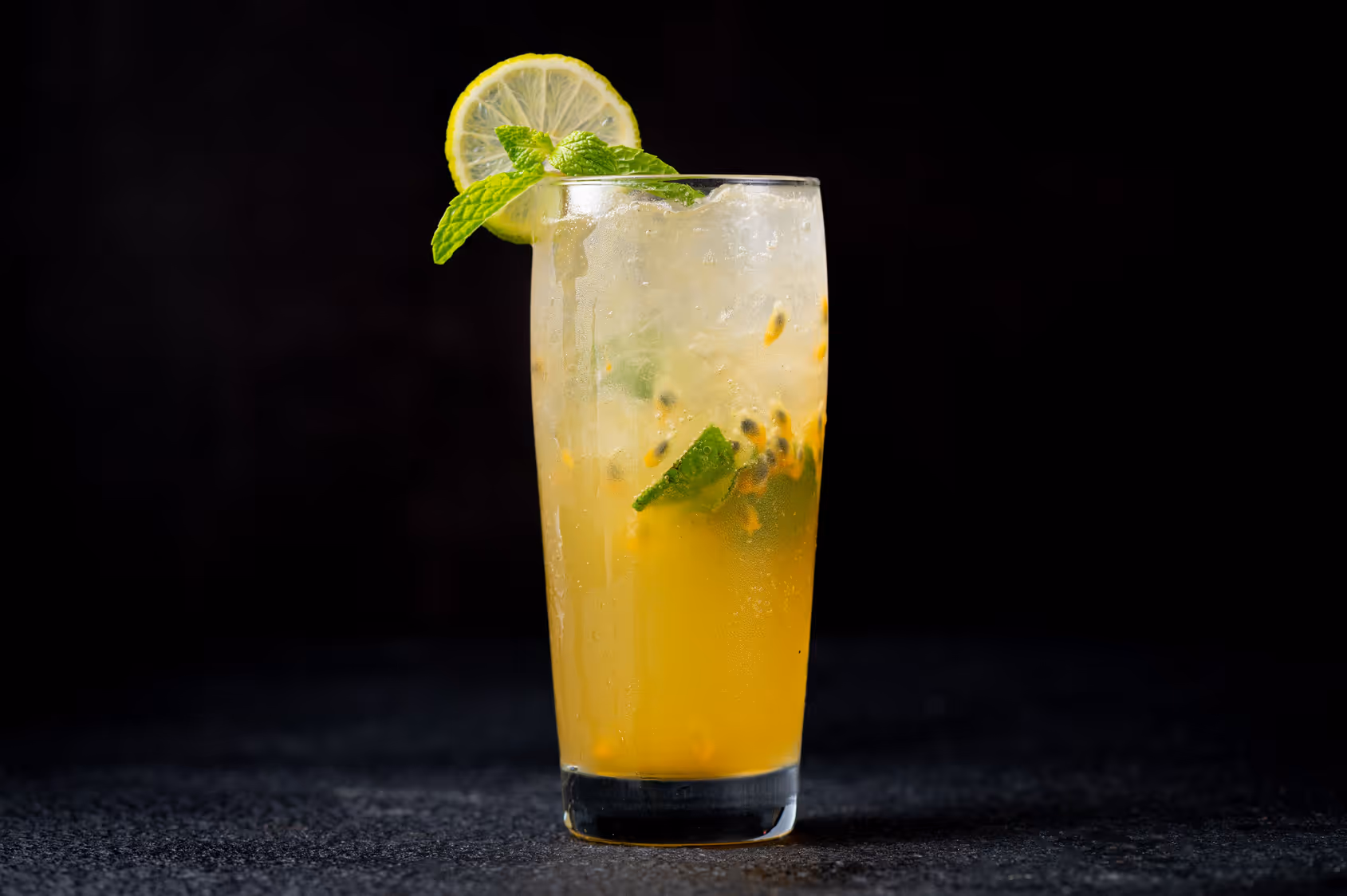Madame Mocktail Passionfruit Mojito zero-proof drink in a tall glass with lime garnish