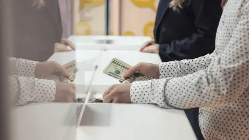 Person handing cash at a store