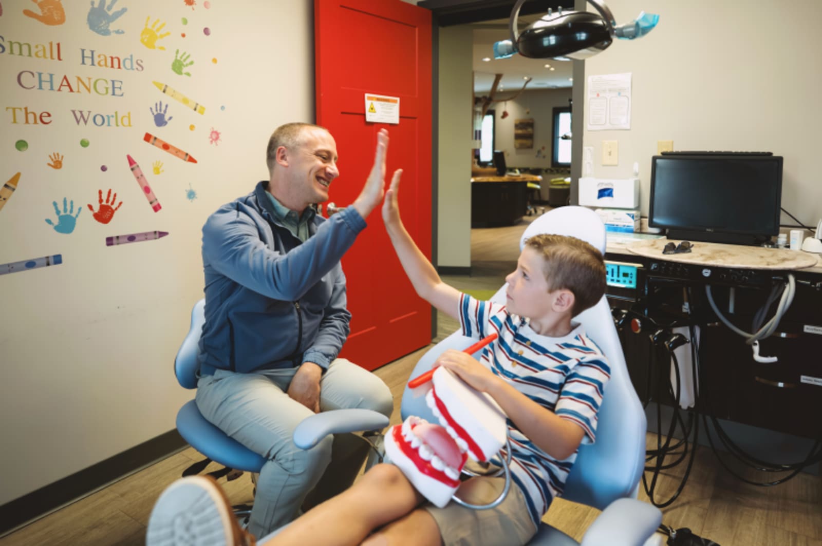 Dentist discussing tooth sensitivity and pain with a young patient in the treatment room