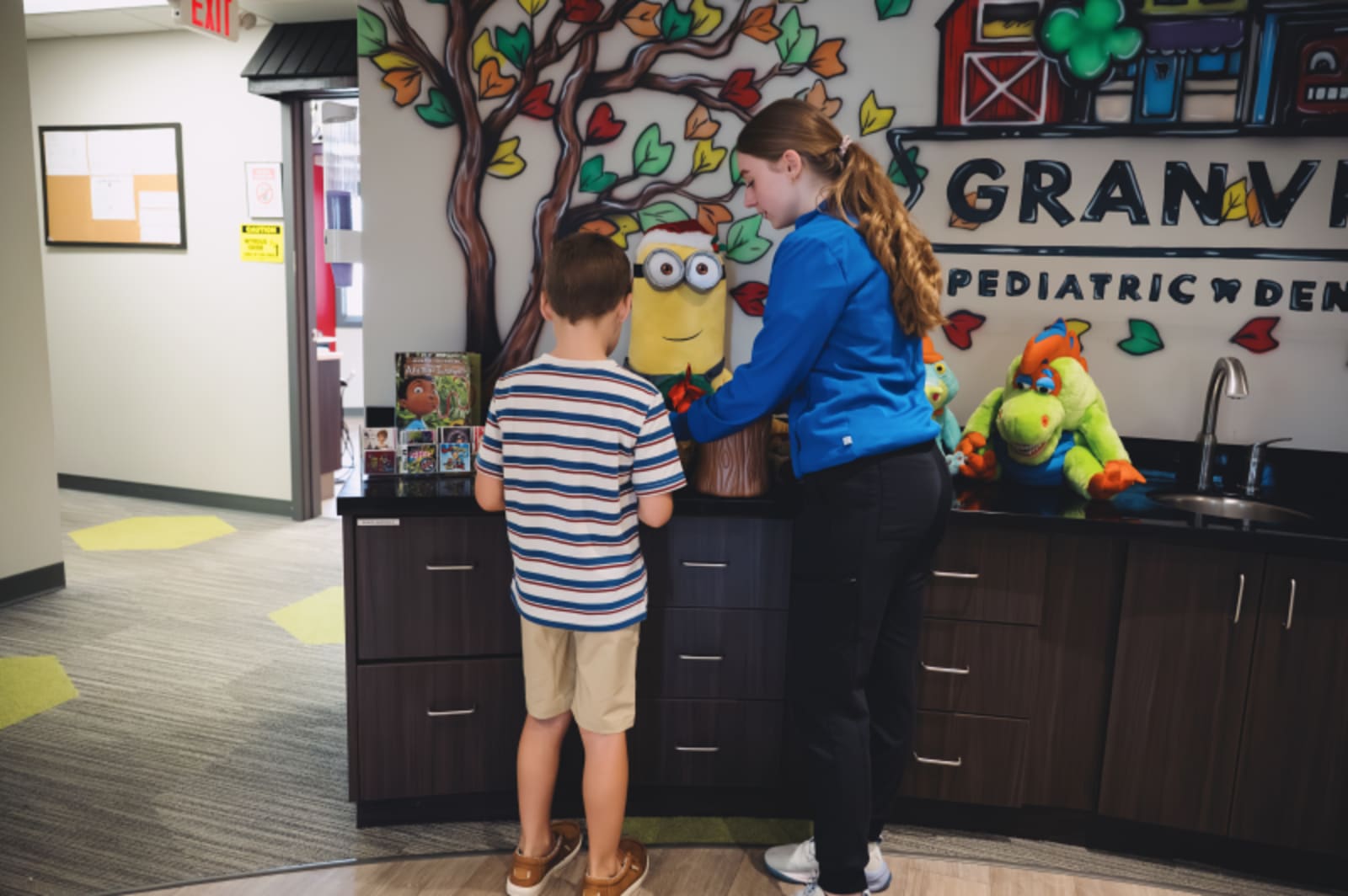 Children and staff greeting each other in the dental office reception area