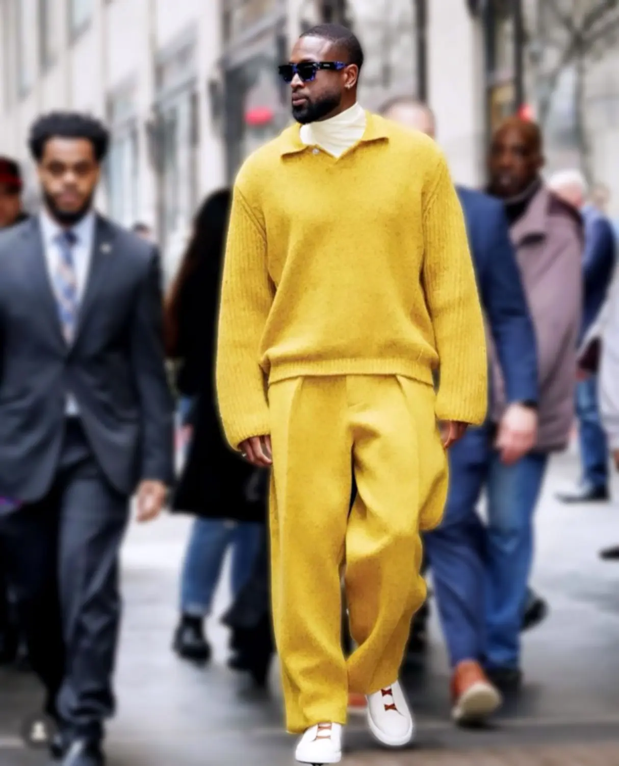 Dwyane Wade steps out in bold monochrome fashion wearing an oversized mustard yellow sweater and matching wide-leg trousers, styled with white sneakers and layered with a turtleneck. Captured by Sepulveda Studio, this street style moment highlights Wade’s fearless fashion sense and modern luxury menswear.
