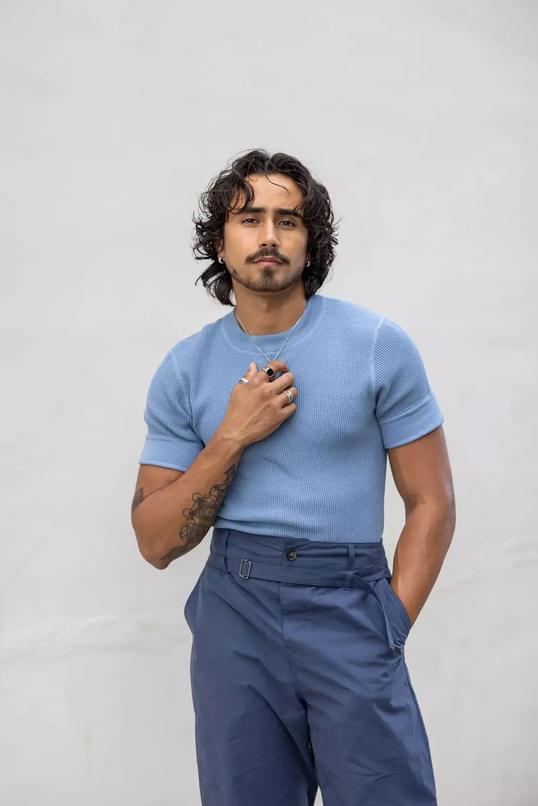 Daniel Sepulveda in a monochromatic blue look, pairing a fitted knit shirt with high-waisted pleated trousers. Captured by Sepulveda Studio in soft daylight for a sharp, yet approachable menswear editorial.