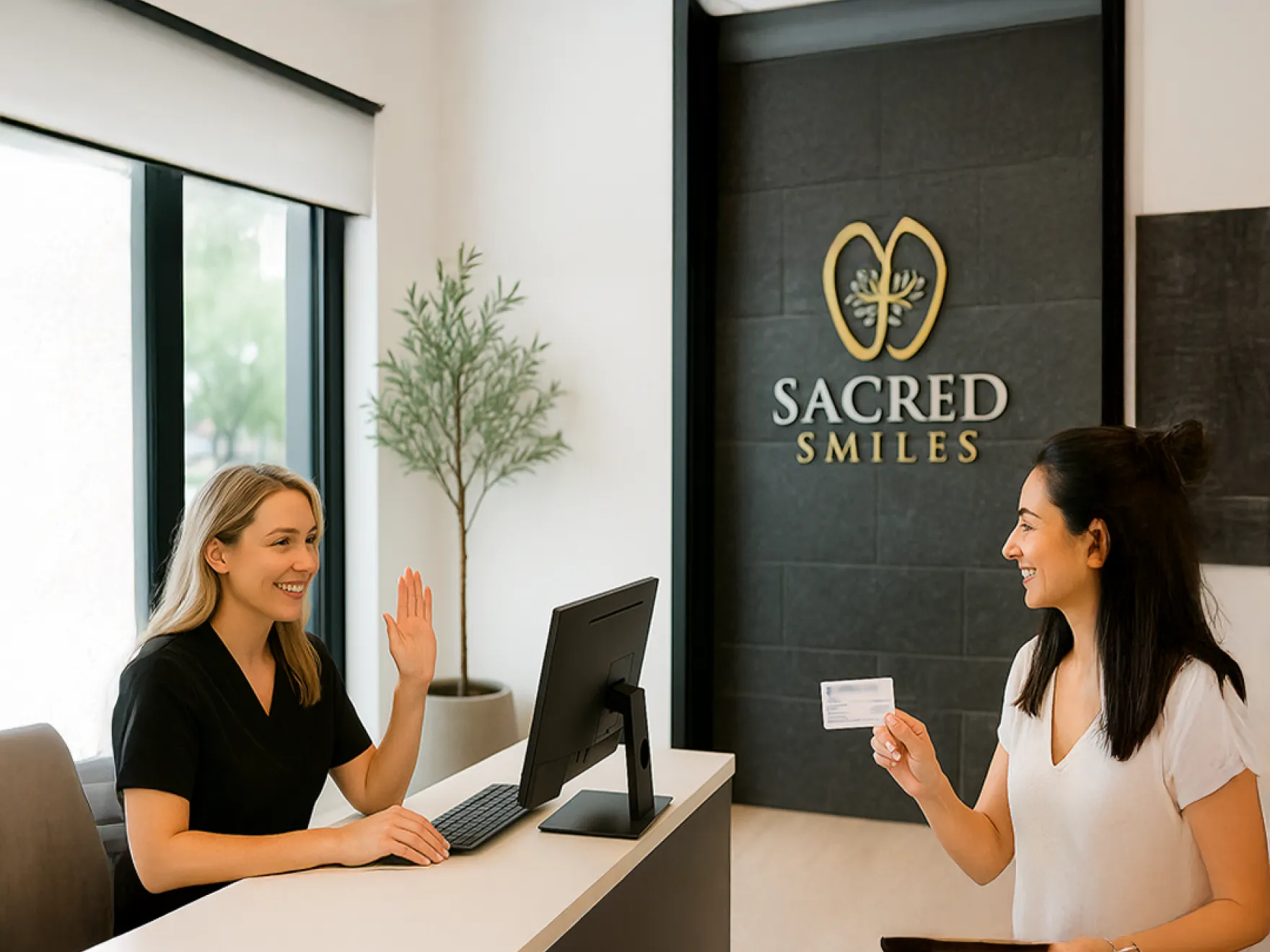 A receptionist greets a woman holding a card at the Sacred Smiles desk.
