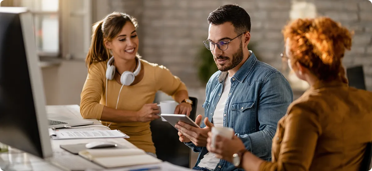 A group of people sitting around a computer.