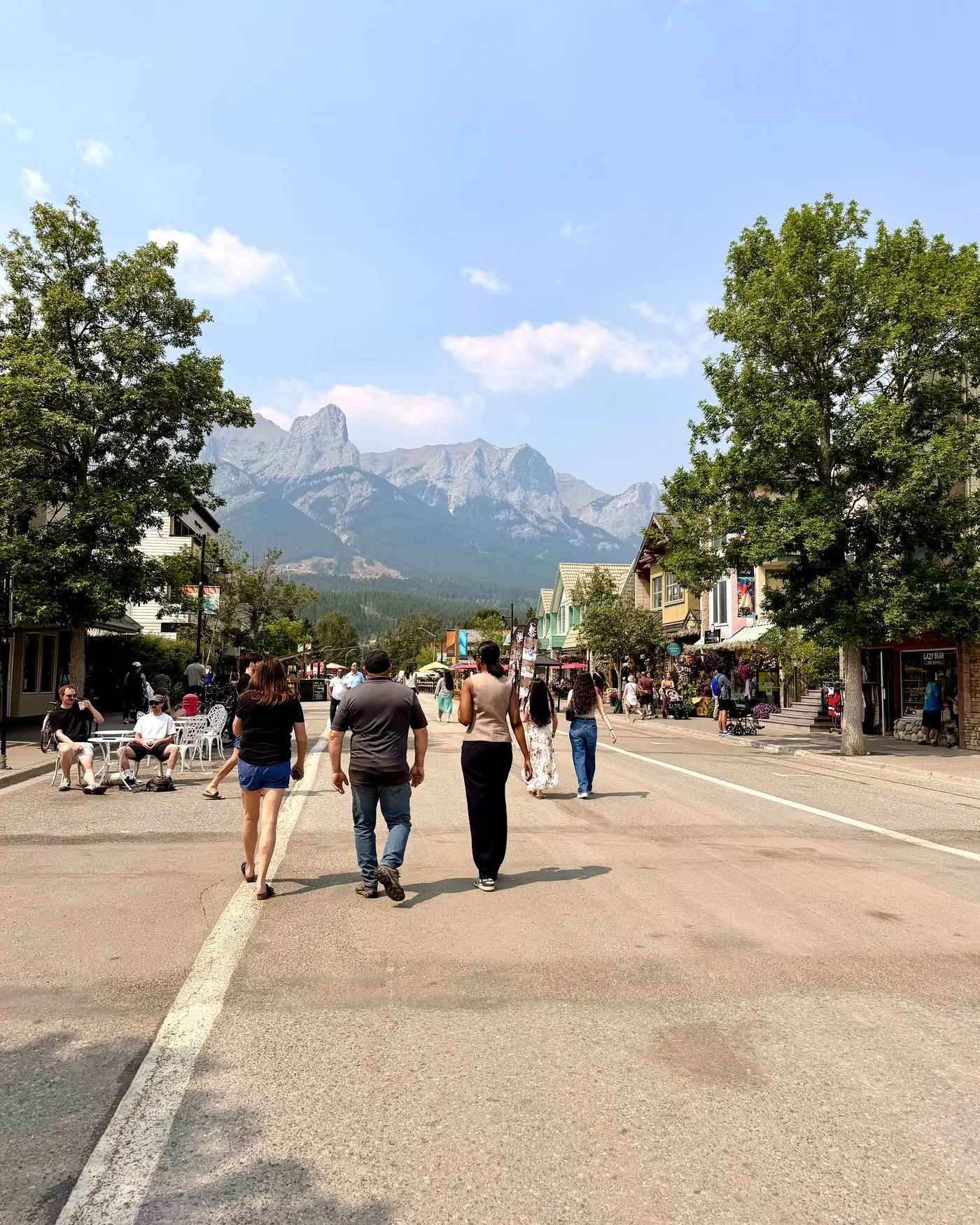 People walking on Main Street Canmore below the Three Sisters, two blocks from Colliery Parc in South Canmore