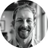 a black and white image of Carl Neilson smiling towards the camera. 