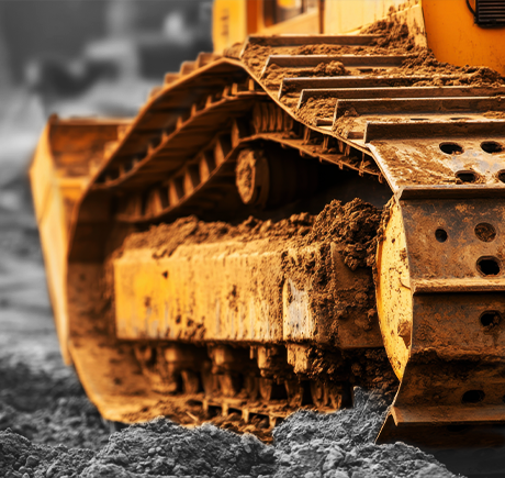 Two construction workers standing near a large excavator 