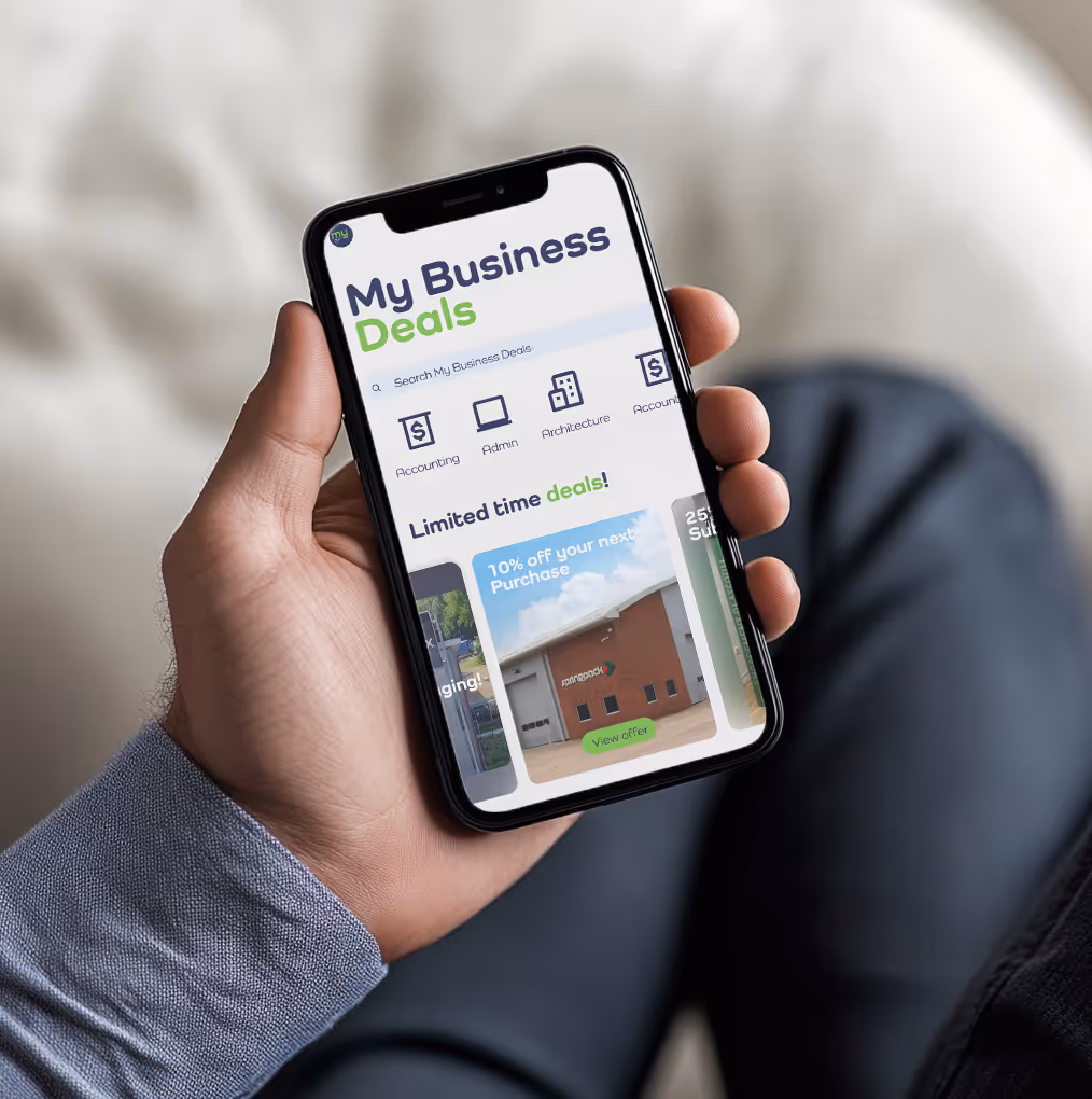 A hand holding a phone showing the My Business Pass app in use