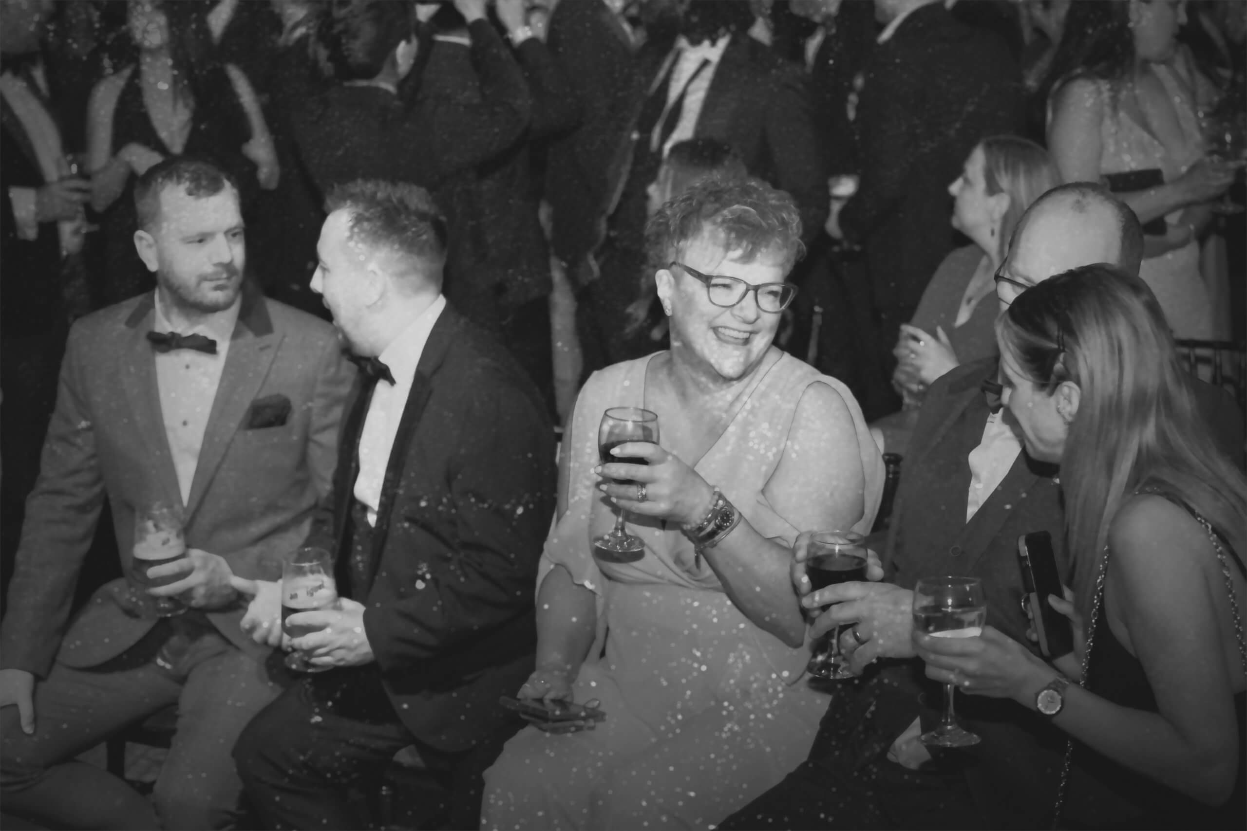 People talking and laughing with drinks at a formal event