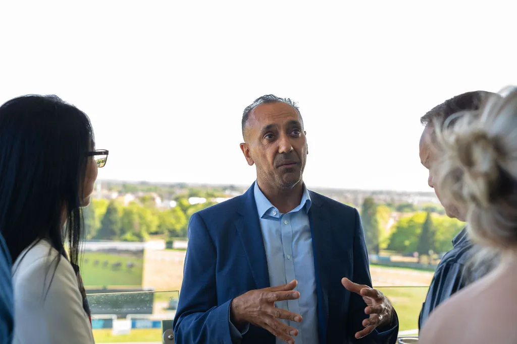 A group of people talking and smiling at the Blue Bricks Horses and Houses property networking event