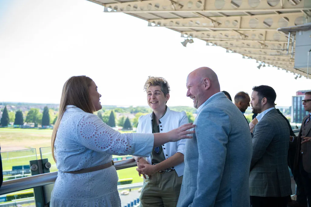A group of people talking and smiling at a the Blue Bricks Horses and Houses networking event.