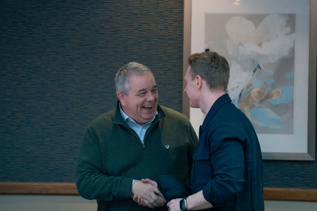 2 men shaking hands and laughing at the Blue Bricks Property and Pigeons networking event