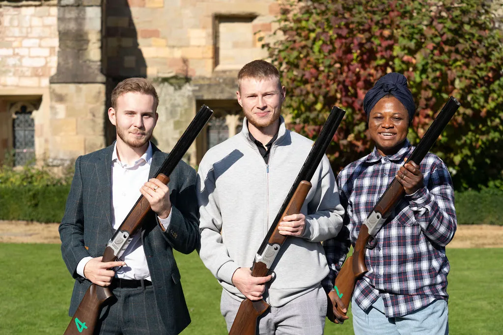 3 people smiling and holding laser pigeon shotguns at the Blue Bricks Property and Pigeons event