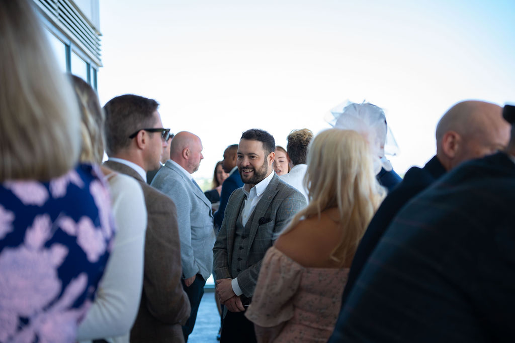 Several groups of people talking on the balcony at Doncaster Racecourse at the Blue Bricks Horses and Houses property networking event