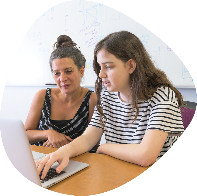 Woman sitting next to a girl doing activities on a laptop.