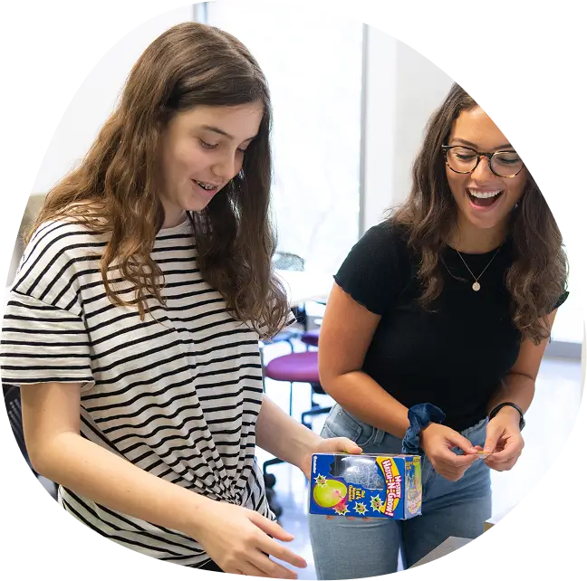 Child participant laughing with a female lab member.
