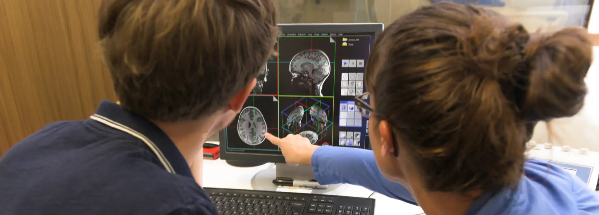 Two people reviewing MRI imagery on a computer.