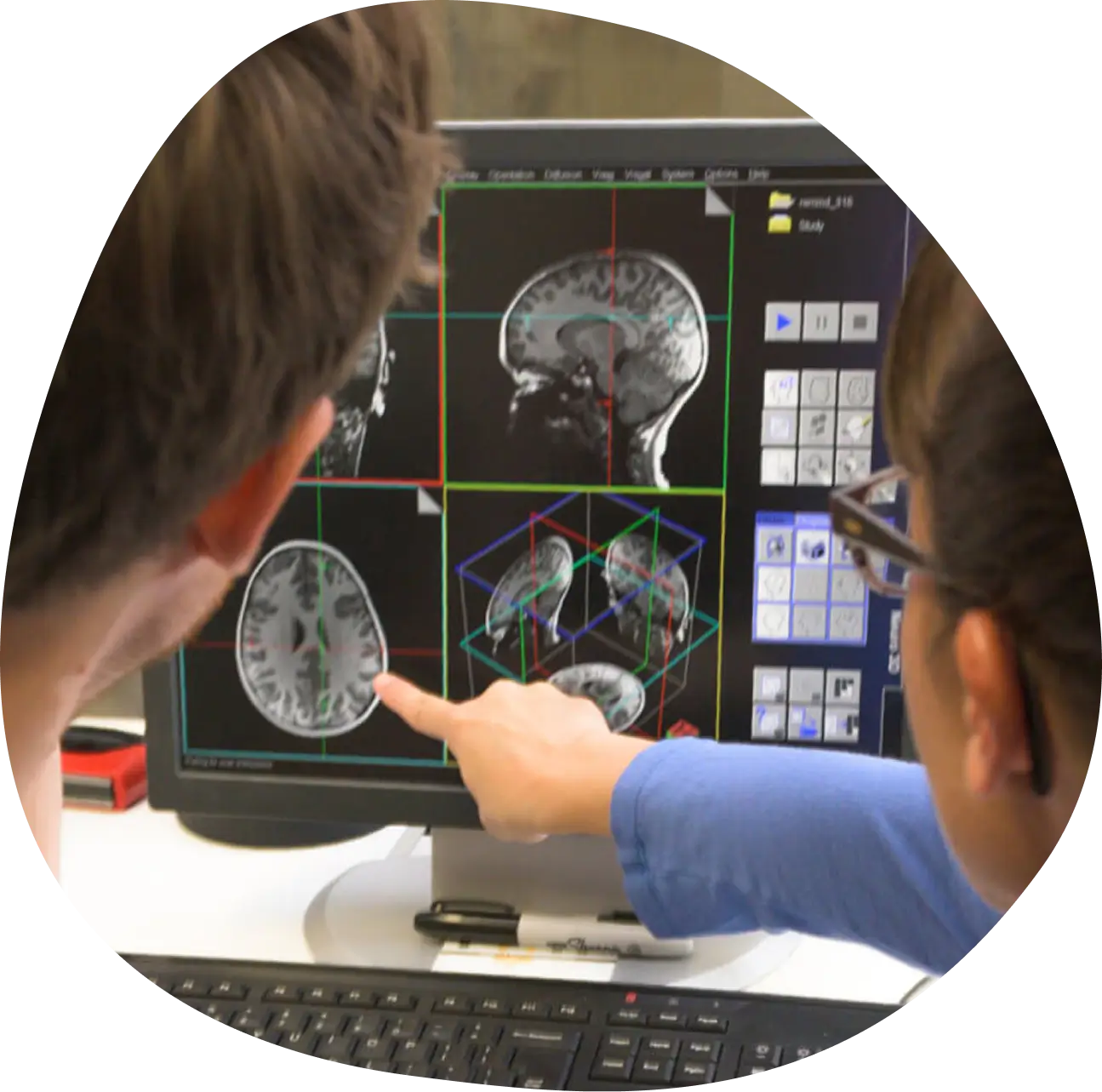 Two people reviewing MRI imagery on a computer.
