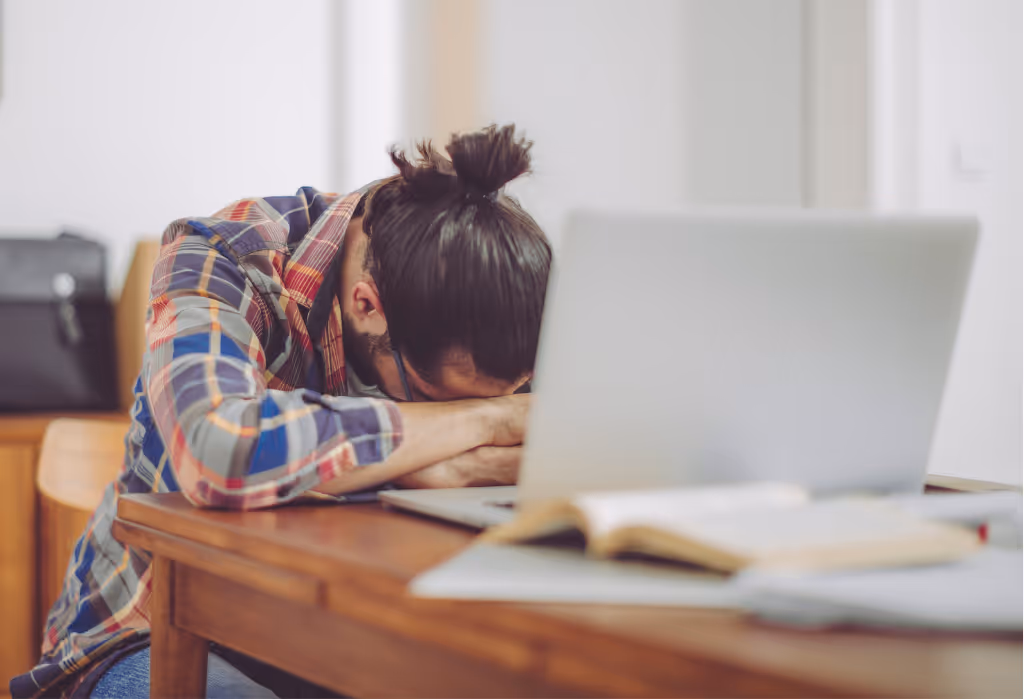 HVAC owner slumped at desk in frustration, showing the stress of missed pitches and inconsistent sales.