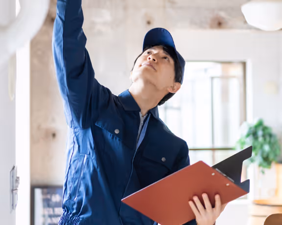 HVAC tech pointing toward ceiling during inspection, symbolizing strategic insight and missed growth potential.