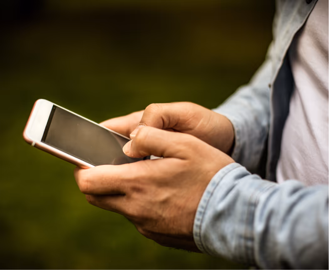HVAC owner holding a smartphone outdoors, representing missed follow-ups and calls that don’t convert to booked work.