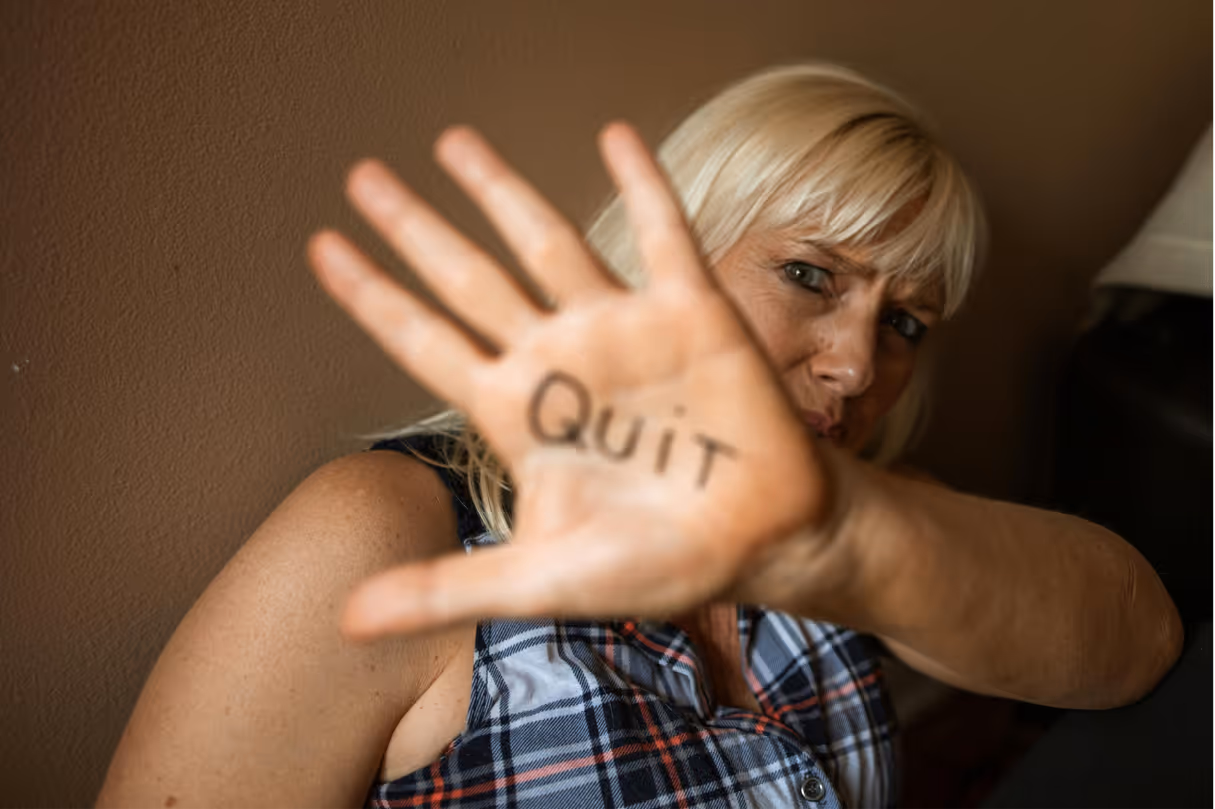 An hvac marketer holds up their hand with the word "Quit" written on it, with a distressed expression.