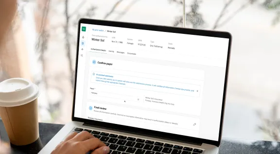 A person's hands typing on a laptop keyboard, with the screen displaying a healthcare authorization form for a patient named "Winter Sol" born on Nov 31, 1988. The interface shows various sections including "Confirm payor" with Humana selected, and a "Final review" section at the bottom. The form appears to be part of a prior authorization system for medical services, with tabs for Authorization Details, Activity, Messages, and Documents visible at the top.